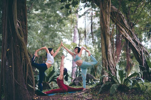 Flexible Women Doing Yoga Outdoors