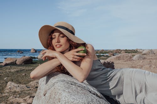 Een Vrouw Met Een Zonnehoed En Een Grijze Jurk Poserend Op Het Strand