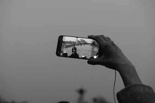 Grayscale Photo of Person Holding a Phone