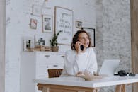 时尚家庭办公室的女性使用智能手机和笔记本电脑进行通讯