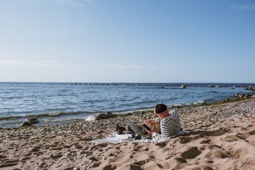 Gente Sentada En La Orilla De La Playa