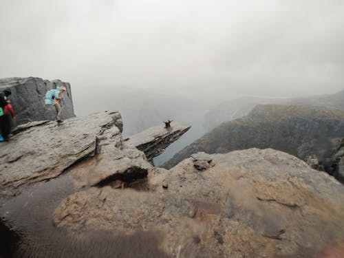 People Standing on the Cliff of the Mountain