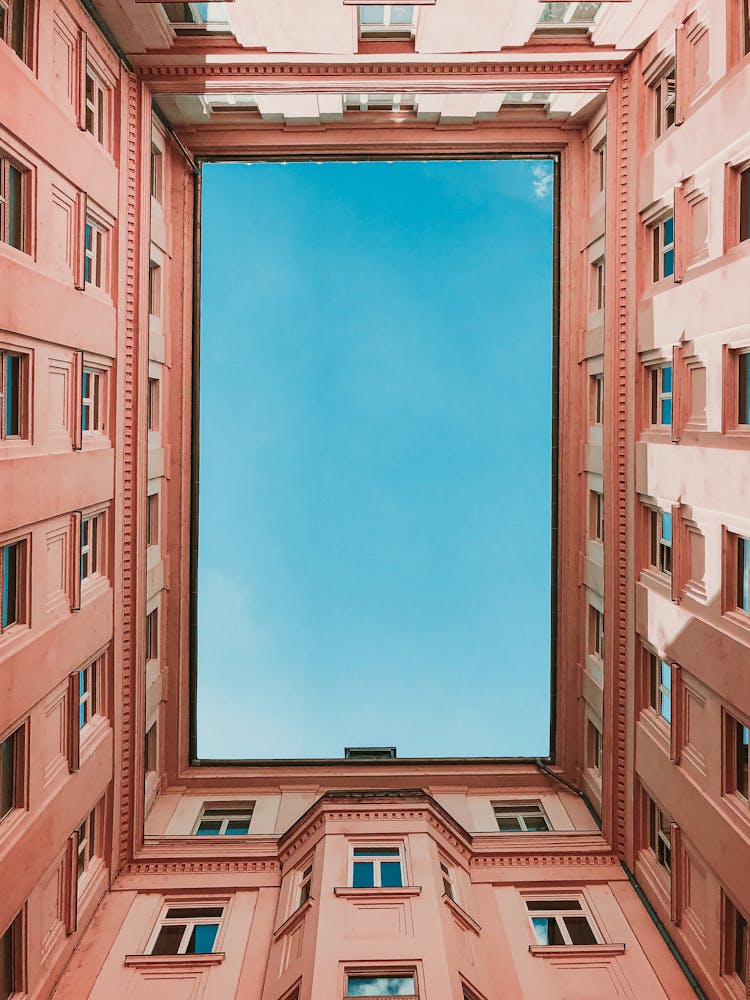 Worm's Eye View Of Pink Concrete Building Under Blue Sky