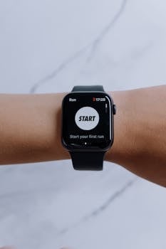 Close-up of a smartwatch showing a running app on a marble background.