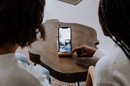 Woman in White Long Sleeve Shirt Holding Silver Iphone 6