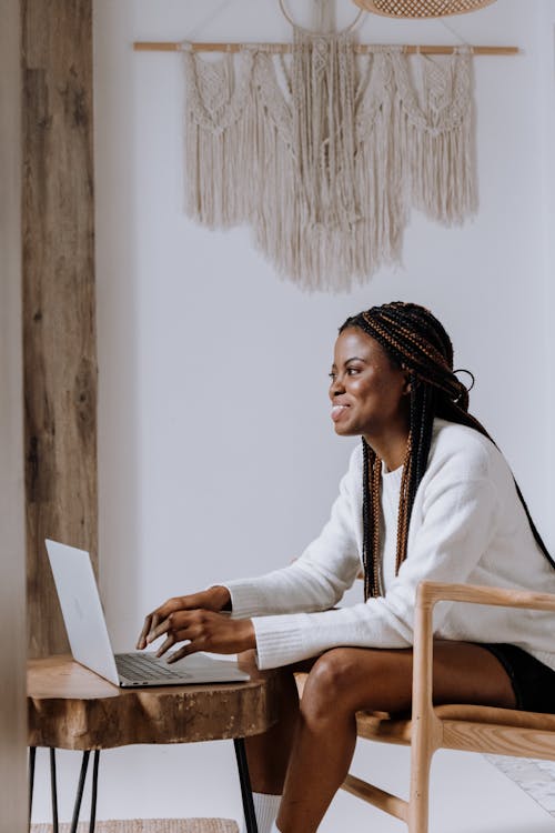 Woman in White Long Sleeve Shirt Sitting on Brown Wooden Chair