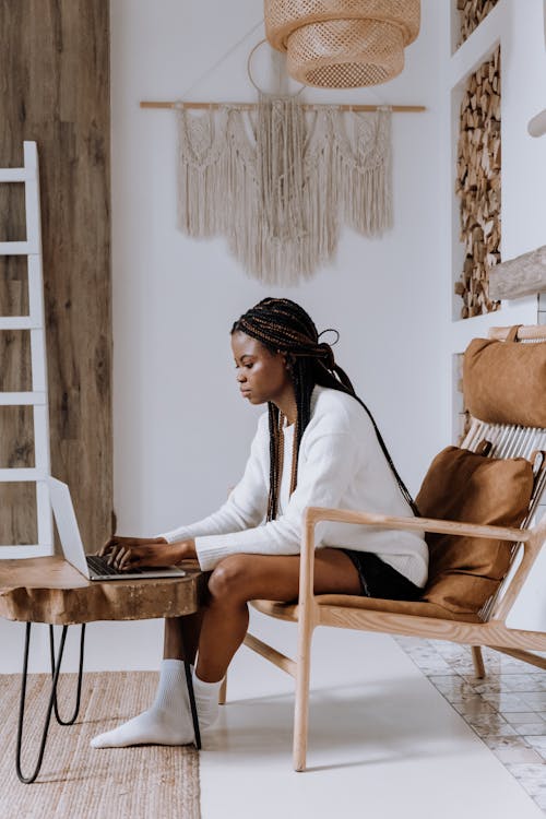 Free Woman in White Long Sleeve Shirt Sitting on Brown Wooden Chair Stock Photo