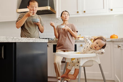 A family of three enjoying breakfast together in a modern kitchen setting.