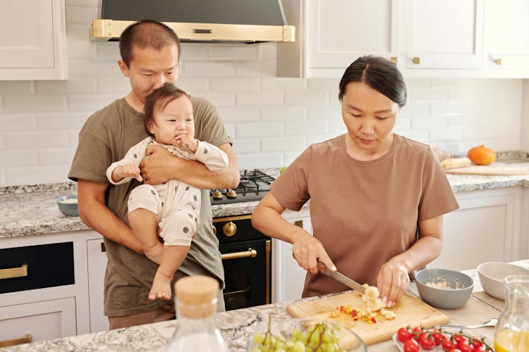 Man Carrying A Baby Beside A Woman