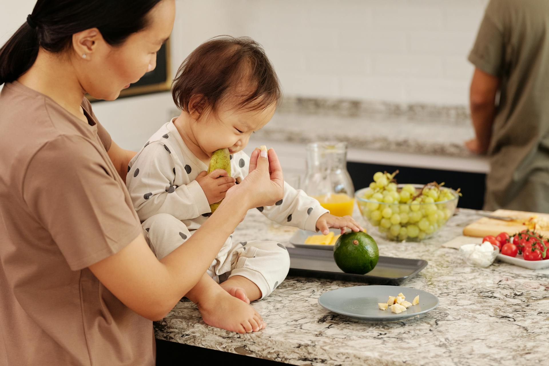 Person Feeding a Baby Girl