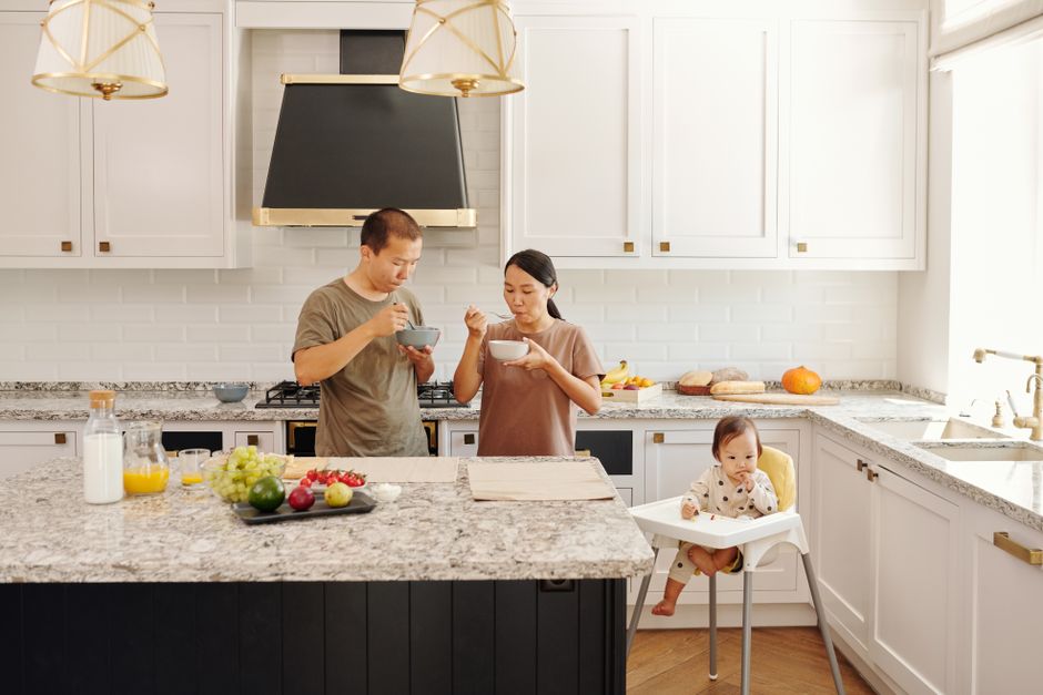 A happy family enjoying a meal together in their newly remodeled, bright, and modern kitchen - personal loan for kitchen remodel A happy family enjoying a meal together in their newly remodeled, bright, and modern kitchen - personal loan for kitchen remodel