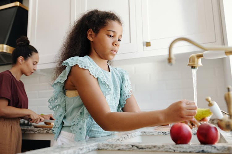 Girl Washing A Fruit