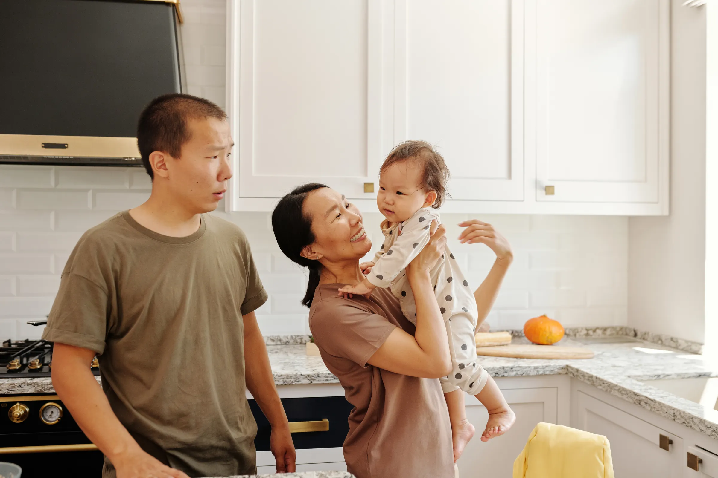 Family talking with baby in a cozy kitchen during everyday bonding time