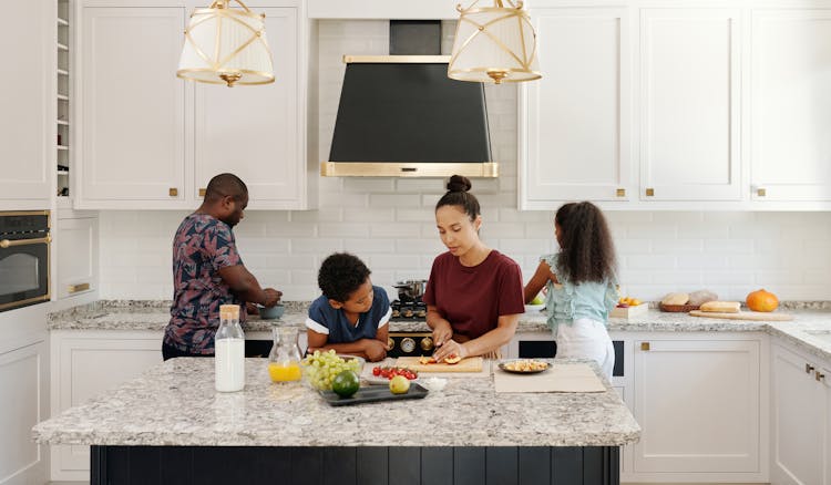 A Family Busy Preparing Food In The Kitchen