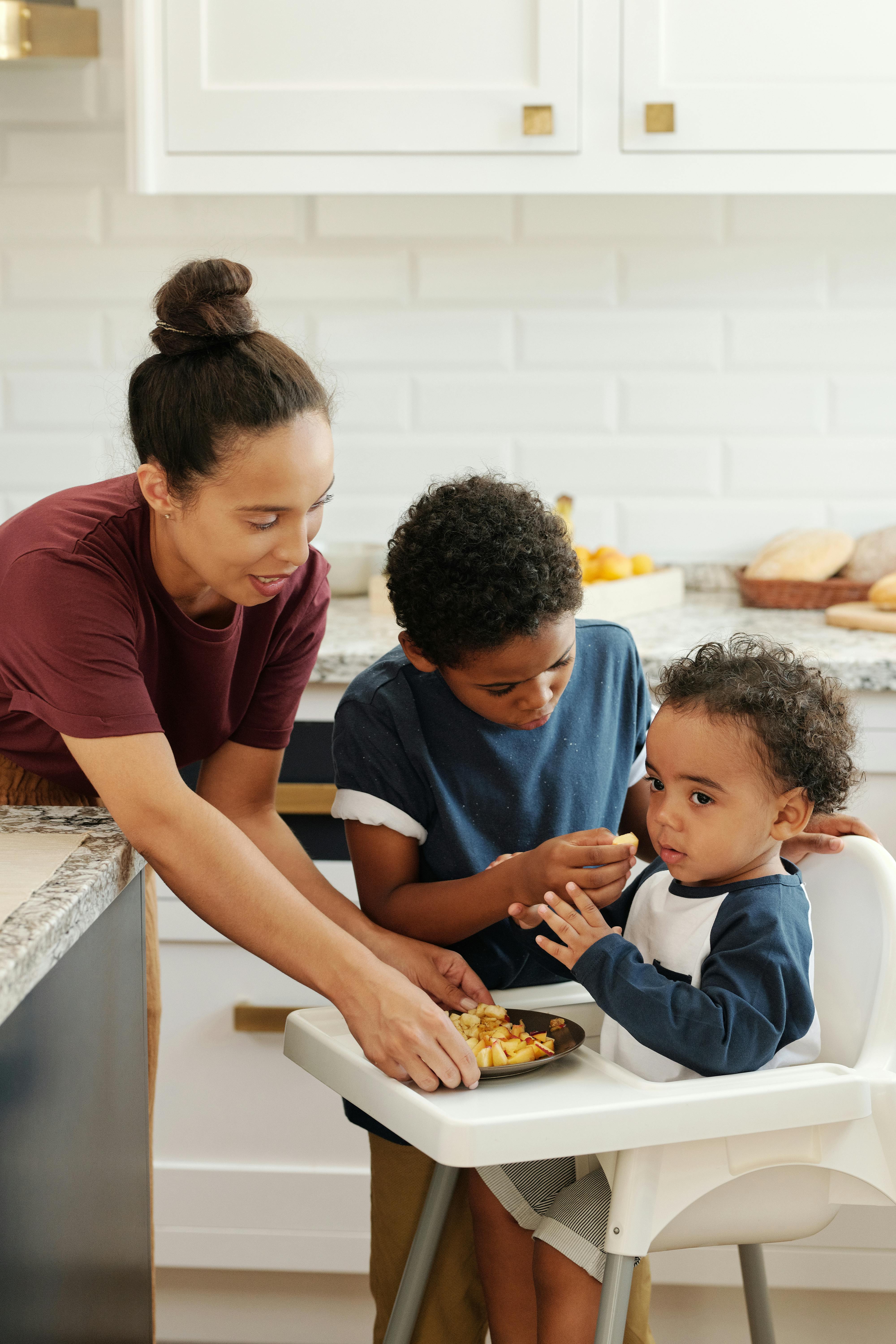 一位母亲在舒适的家庭厨房里帮孩子们做饭
