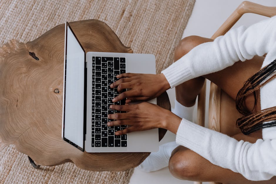 Person in White Long Sleeve Shirt Using Macbook Pro