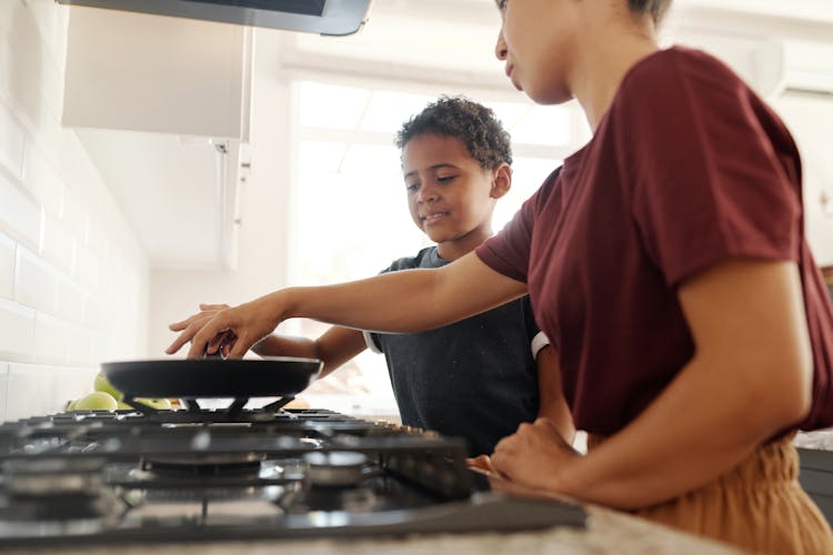 Mother And Son Cooking Busy Cooking On The Frying Pan