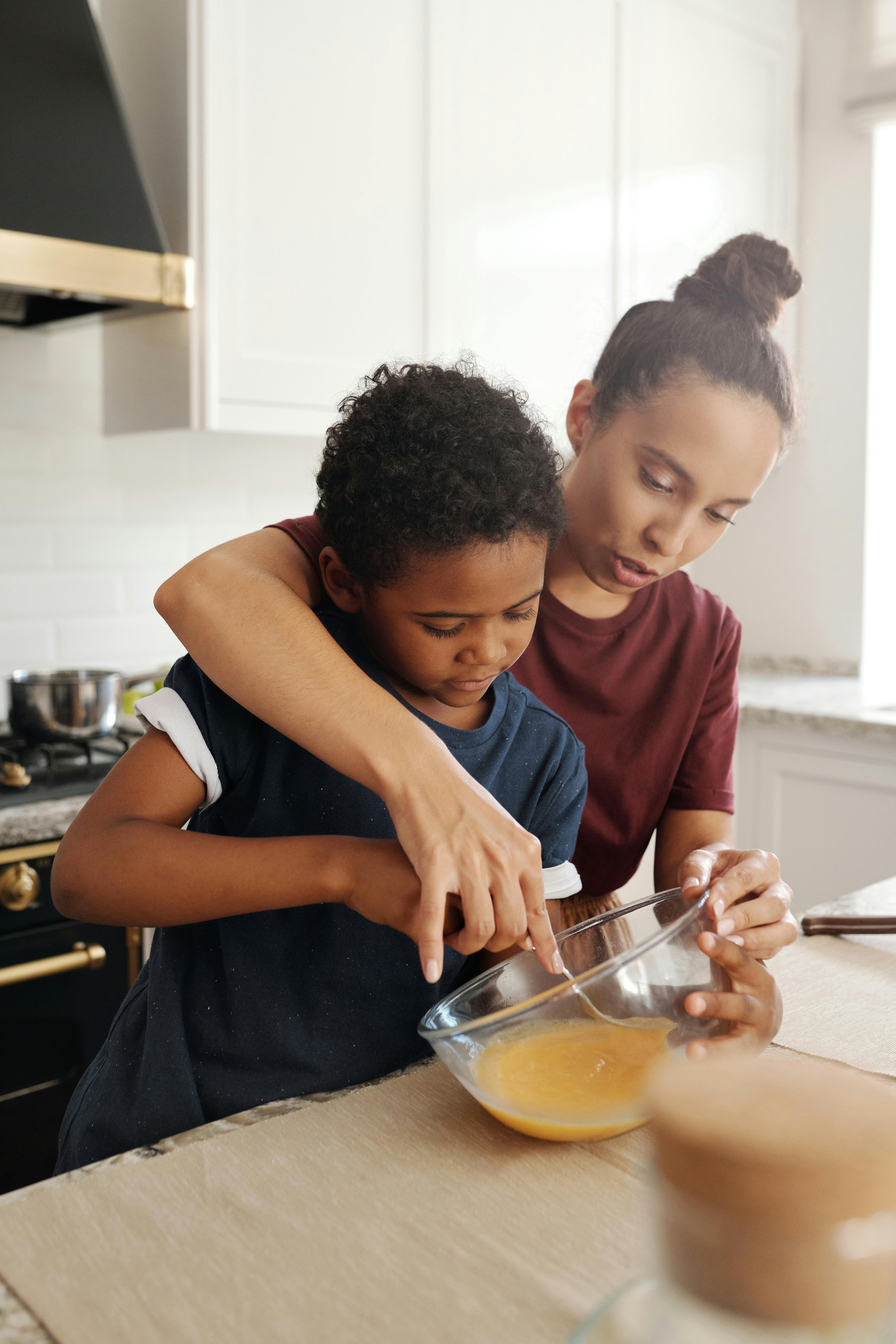 a mother teaching his son how to bait the egg on the bowl