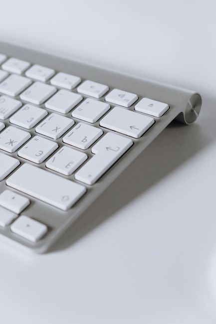 Fotomural Acercamiento a un teclado inalámbrico blanco moderno, perfecto para entornos digitales y de oficina.
