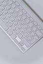 White Apple Keyboard on White Table