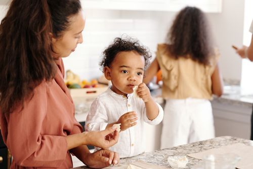 Free A mother and son bonding over food in a warm, family kitchen setting. Stock Photo