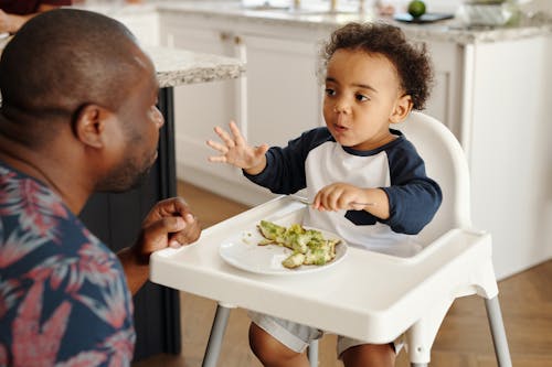 Man Feeding Baby in Feeding Chair