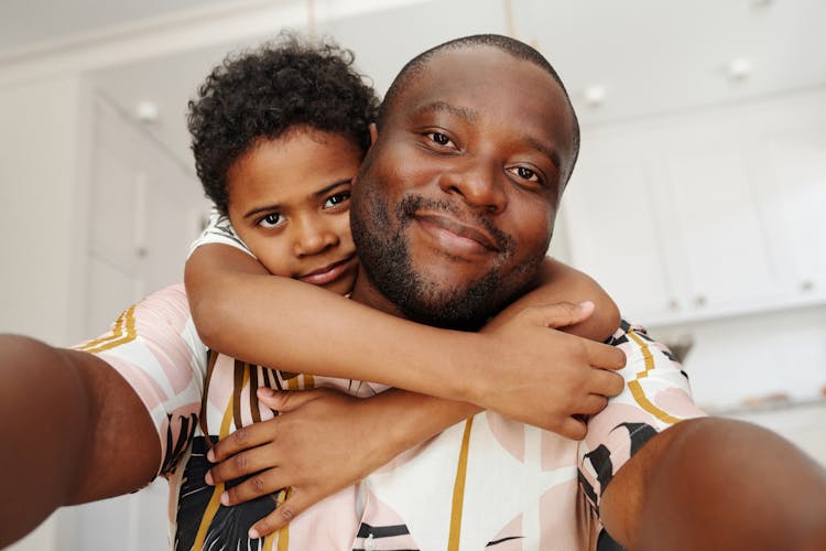 Boy Hugging His Dad While Taking Selfie