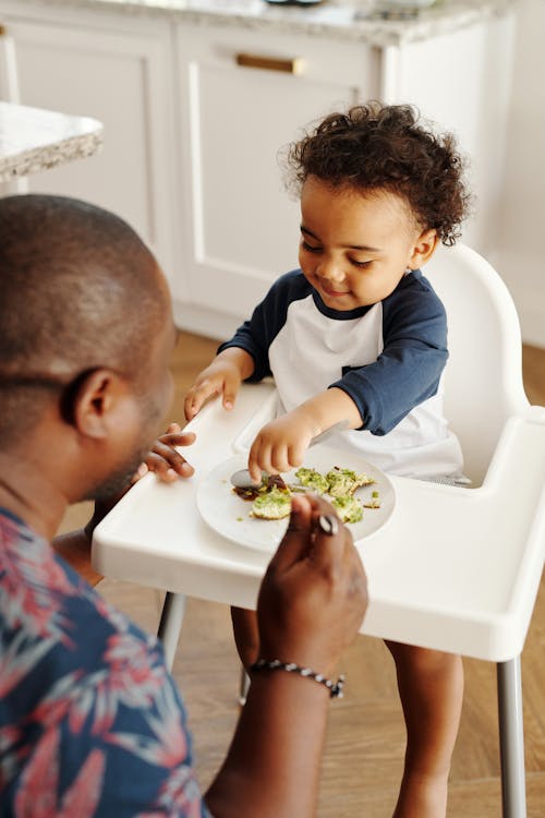 Man Feeding Baby in Feeding Chair