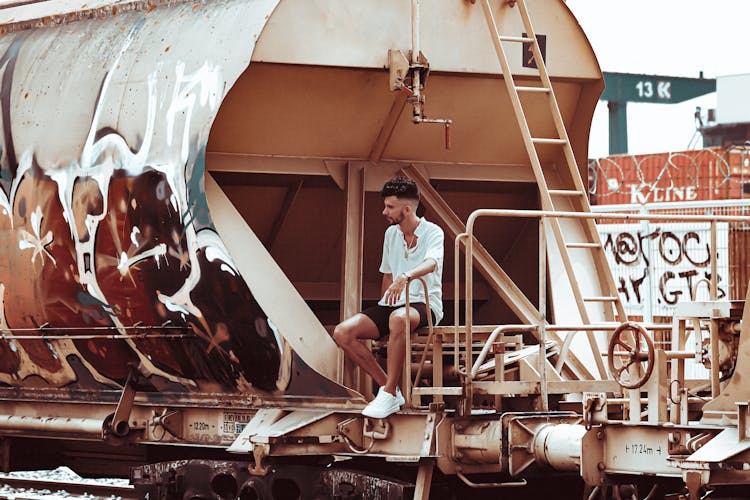 Man Sitting On Car Of Freight Train