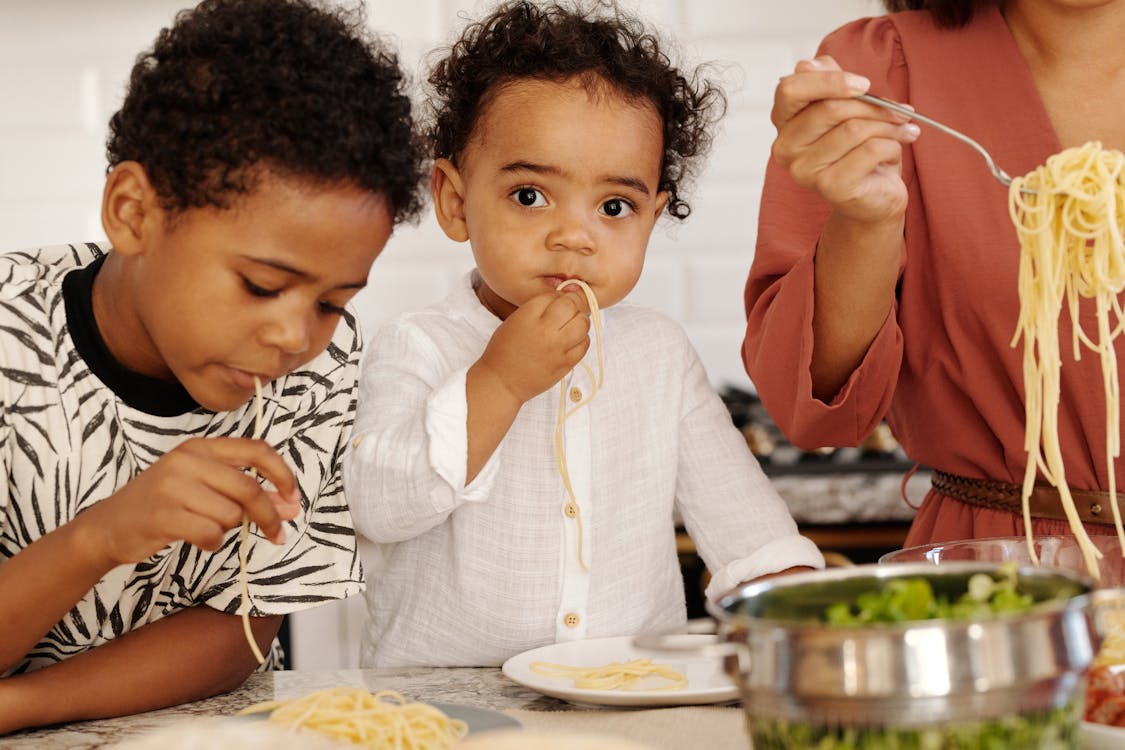 A Young Boys Eating Pasta