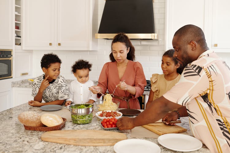 A Family Preparing Food In The Kitchen Togeher