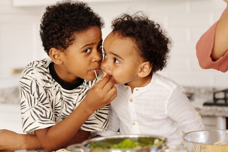 Young Boys Eating Pasta Together