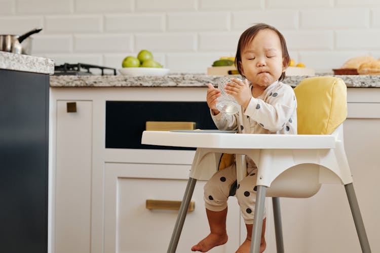 A Toddler On A Baby Sir Drinking Water