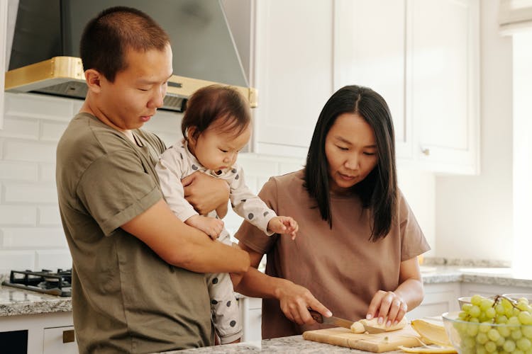 A Family Preparing Healthy Baby Food In The Kitchen