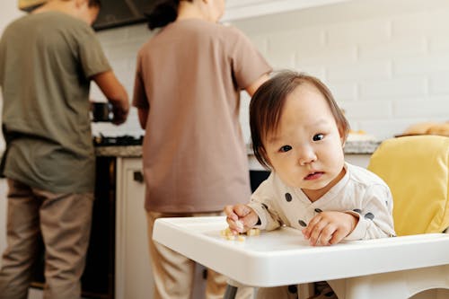 Free A Cute Toddler Sitting on a High Chair  Stock Photo