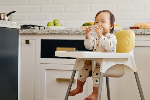 Beyaz Uzun Kollu Gömlekli Bebek Beyaz Yüksek Sandalyede Oturuyor