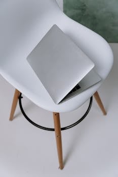 Top-down view of a laptop on an Eames chair, showcasing minimalist modern design.