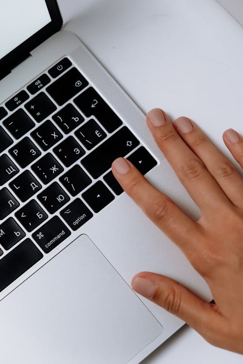 Free Persons Hand on Macbook Pro Stock Photo