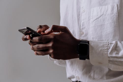 Person in White Dress Shirt Holding Black Smartphone