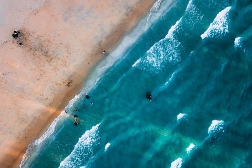 Free Aerial view of turquoise foamy ocean water washing sandy beach on summer day Stock Photo
