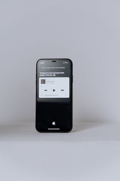 شخص يستخدم هاتف آيفون مع المساعد الذكي Siri AI