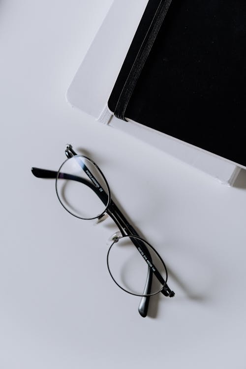Free Black Framed Eyeglasses on White Table Stock Photo