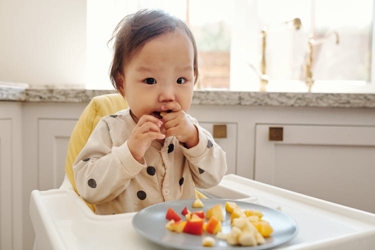 A Toddler Eating Fresh Fruits