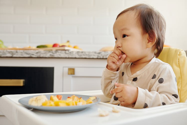 A Toddler Eating Fresh Fruits