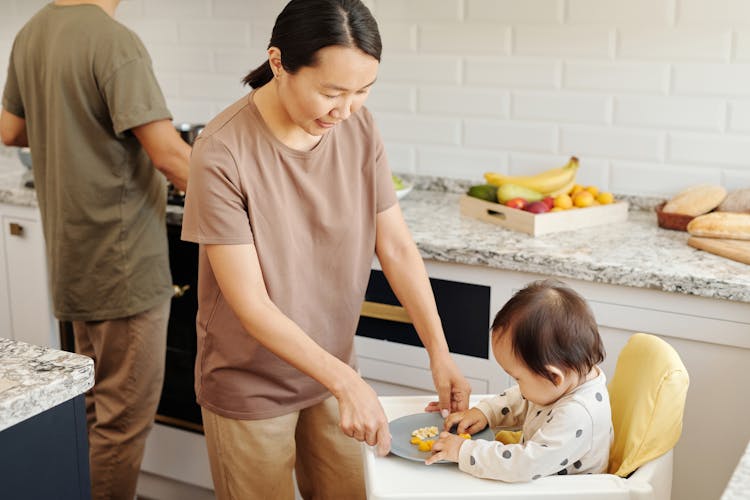 A Mother Feeding Her Child With Fresh Fruits