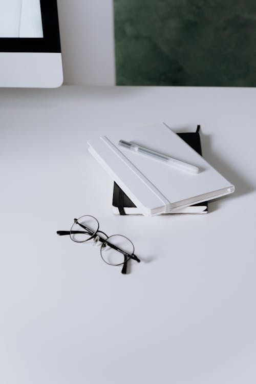 Free Black Framed Eyeglasses on White Table Stock Photo