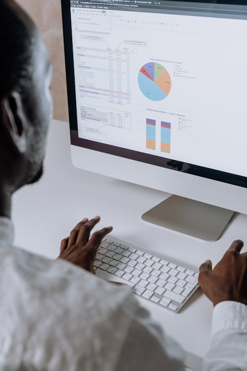 Free Person in White Long Sleeve Shirt Using Imac Stock Photo