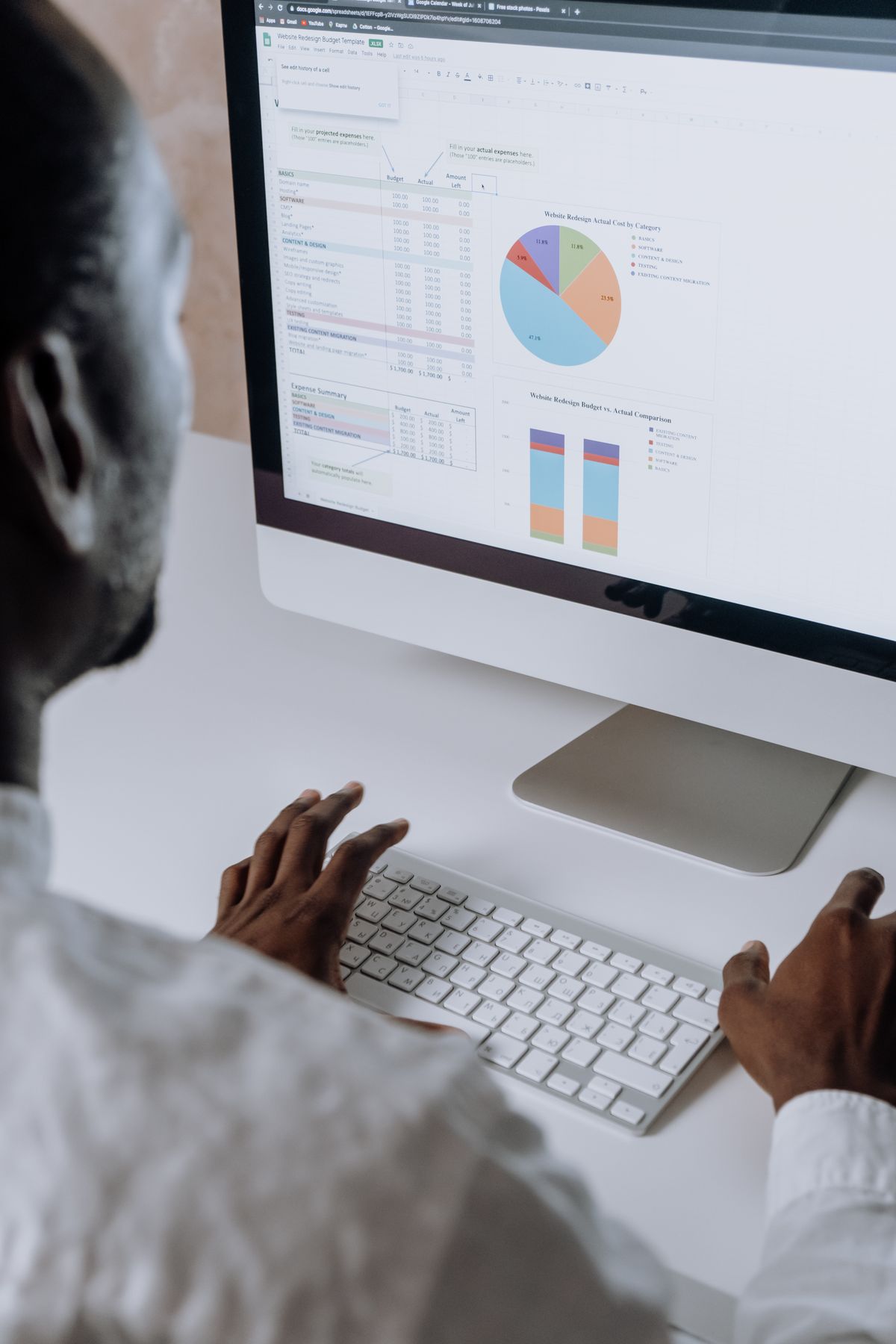 African professional reviewing software analytics on a computer