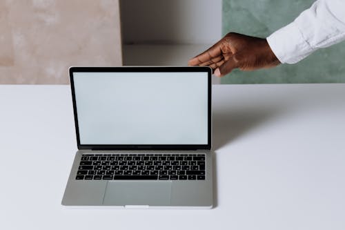 Free Person Using Macbook Pro on White Table Stock Photo