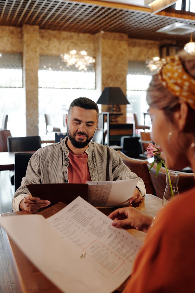 A Couple Looking At The Menu